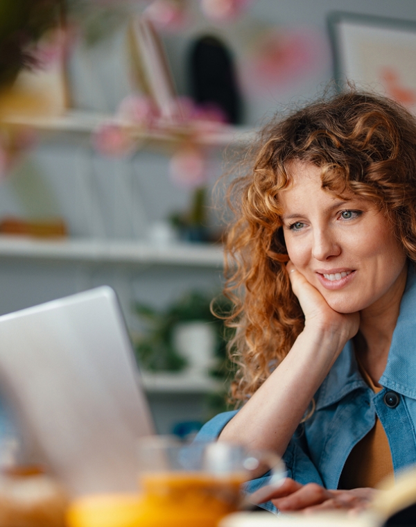 Woman reviewing EOR service provider comparison on laptop.